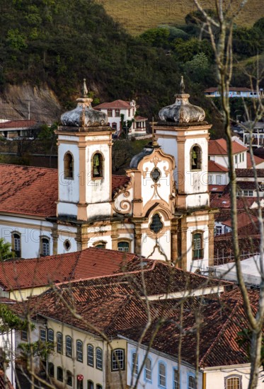 Church between the roofs of the colonial houses in the city of Ouro Preto in Minas Gerais, Ouro Preto, Minas Gerais, Brazil