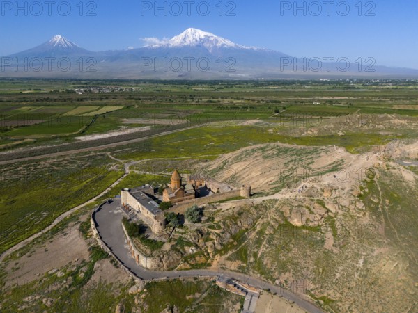 Historical monastery in mountain landscape with blue sky and wide nature, aerial view, monastery Chor Wirap, Chor Virap, deep dungeon, in the background the Ararat and the small Ararat, located in Turkey, Ararat province, Armenia