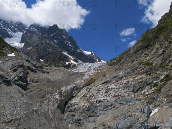 Impressive glacier landscape with rocks and mountains dominated by a clear blue sky and clouds, aerial view, Chalaadi glacier, Mestia, Svaneti, Caucasus, Georgia