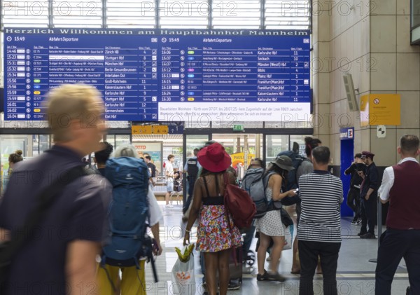 Mannheim main station, interior view with people and display board. Mannheim, Baden-Württemberg, Germany