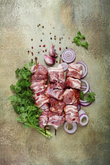 Raw pork meat, on wooden skewers, pickled kebab, with spices and herbs, on the table, top view, no people