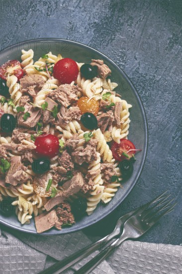 Fusilli pasta salad with canned tuna, cherry tomatoes and olives, parmesan, microgreens, homemade, no people