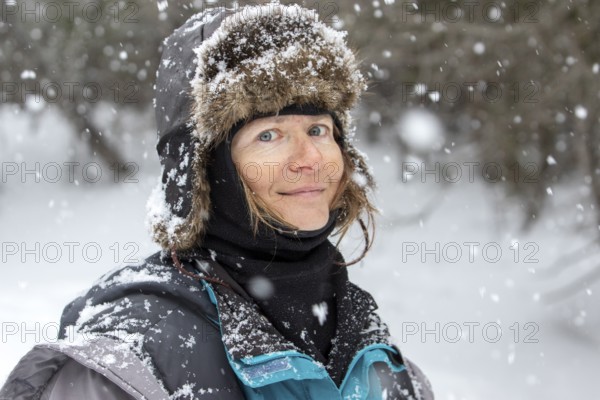 Woman enjoying a cold weather, Woman smiling under a snowfall, Gaspesie national park, Province of Quebec, Canada, north America