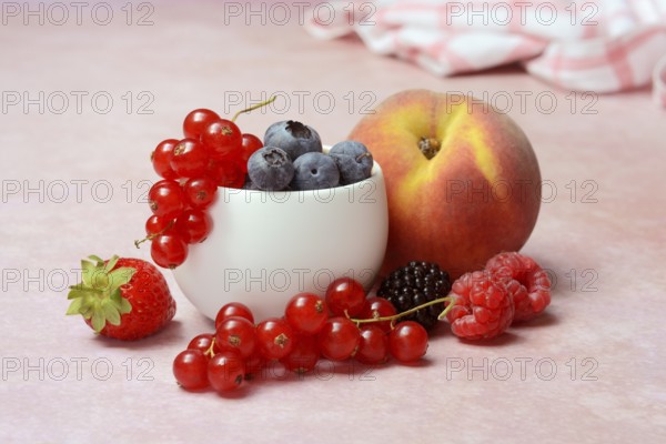 Various fruits in peel, redcurrant, peach, strawberry, blueberry, blackberry, raspberry