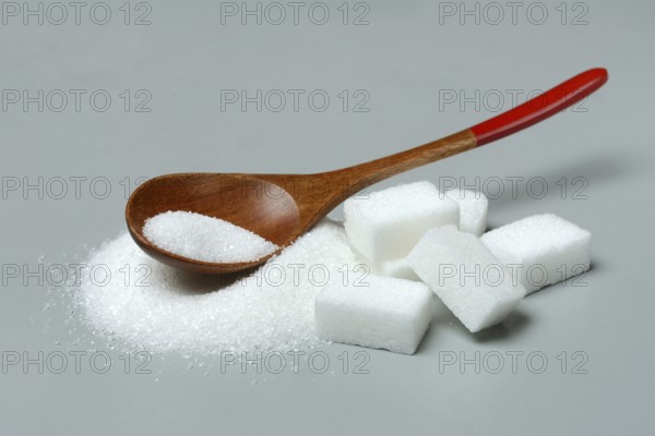 Sugar with wooden spoon and sugar cube