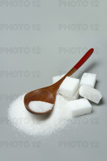 Sugar with wooden spoon and sugar cube