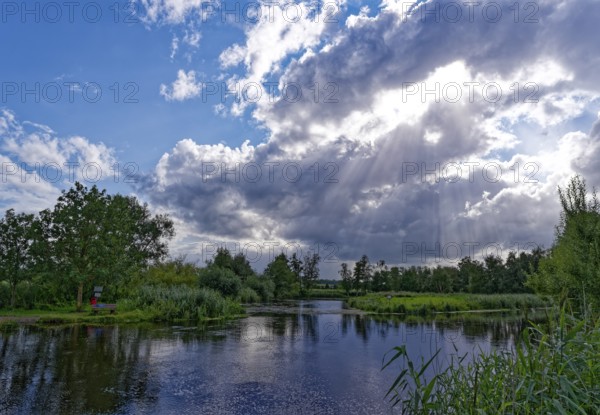 Sun and clouds over the River Trave in Brenner Moor. The Brenner Moor is a salt moor, FFH area, in the Trave lowlands near Bad Oldesloe. Schleswig-Holstein, Germany