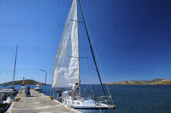 A sailing boat moors in sunny weather at a pier in the deep blue sea, Analipsi, Maltezana, Astypalea, Astipalea, Astipaleia, Dodecanese, Greek Islands, Greece