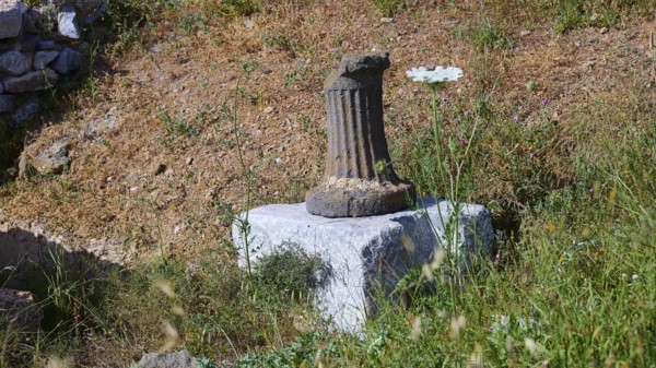 An old column on a pedestal surrounded by grass at a historical site, ancient Roman bath, Tallaras, Analipsi, Maltezana, Astypalea, Astipalea, Astipaleia, Dodecanese, Greek Islands, Greece