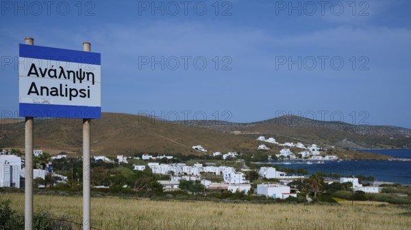 A town sign in front of a coastal settlement with whitewashed houses and blue sky, Analipsi, Maltezana, Astypalea, Astipalea, Astipaleia, Dodecanese, Greek Islands, Greece