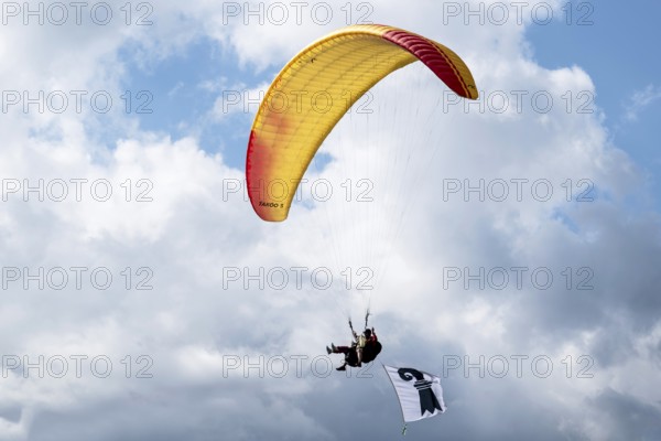 Paragliding tandem flight with Baselstadt flag, Interlaken, Switzerland
