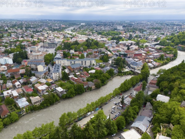 Urban panoramic view with river surrounded by dense residential areas and green trees under a cloudy sky, aerial view, Kutaisi, Kutaisi, Imereti region, Georgia, Asia