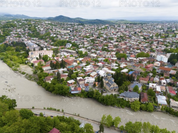 Overview of a hilly cityscape with river, residential buildings and a prominent church, aerial view, Kutaisi, Kutaisi, Imereti region, Georgia, Asia