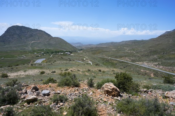 Wide landscape with hills and a winding road under a blue sky, view from the Tukh Manuk Pass to the border triangle of Armenia, Turkey and the Azerbaijani enclave of Nakhchivan, Nakhichevan, Iran can be seen behind Turkey, M2, Armenia