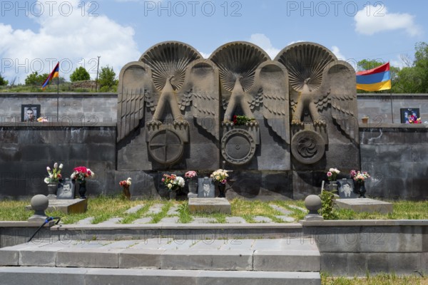 Stone monument with figures of angels and flowers, framed by an Armenian flag, cemetery, Sisian, Sisian, Sjunik province, historical Sangesur, Armenia