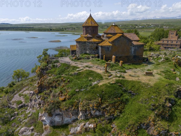 Church on a rocky outcrop, surrounded by lush greenery, overlooking a tranquil lake, aerial view, Hajrawank Monastery, Hayravank, Lake Sevan, Gegharkunik Province, Armenia