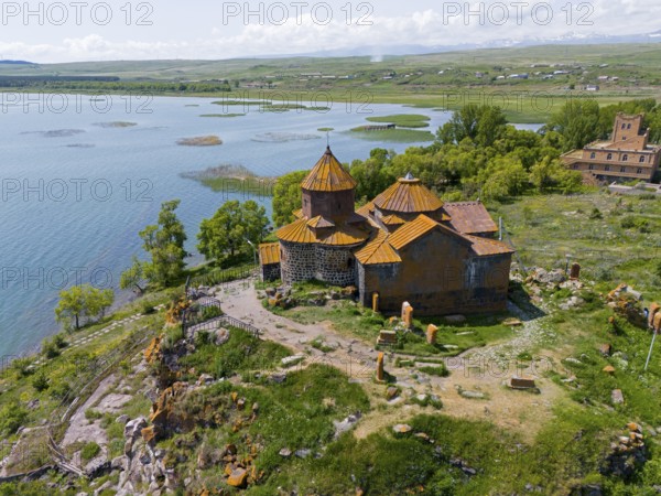 Historic church on the shore of a lake, surrounded by lush nature and clear skies, aerial view, Hajrawank Monastery, Hayravank, Lake Sevan, Gegharkunik Province, Armenia