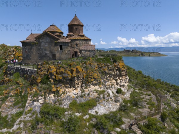 Historic church on a hill overlooking a lake under a bright blue sky, aerial view, Hajrawank Monastery, Hayravank, Lake Sevan, Gegharkunik Province, Armenia