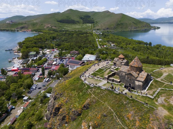 Aerial view of a busy monastery on a hill surrounded by a lake, mountains and a small village, aerial view, Sevanavank Monastery, Sevan Monastery, Gegharkunik Province, Armenia