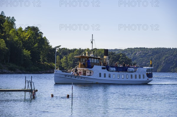 The MS SUNNINGEN, an archipelago boat, approaches the landing stage in the historic seaside resort of Gustafsberg in Uddevalla, Bohuslän, Västra Götalands län, Sweden, for editorial use only