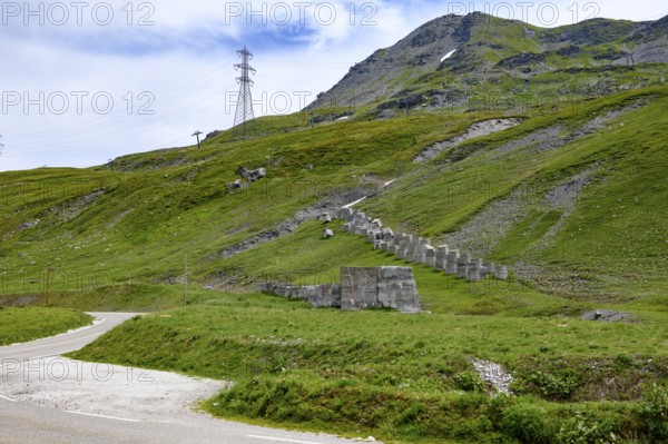 Left pass road from Little Saint Bernard Pass right next to it historical border fortification military border security from World War II in the form of concrete blocks blocks of concrete at the border 2188 metre high border pass in the Alps between France and Italy, Col du Petit Saint-Bernard, Colle del Piccolo San Bernardo, Département Savoie, France, Region Valle d'Aosta, Italy