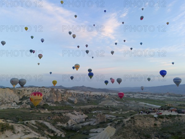 Many colourful hot air balloons float over a vast Turkish landscape in the early morning, aerial view, Göreme National Park, Göreme Tarihî Millî Parki, Nevsehir Province, Nevsehir, Cappadocia, Cappadocia, Kapadokya, Cappadocia, Central Anatolia, Turkey