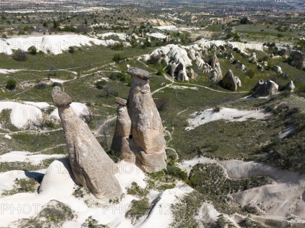 High rock formations in hilly landscape with green areas, aerial view, fairy chimneys near Ürgüp, Göreme National Park, Göreme Tarihî Millî Parki, Nevsehir Province, Nevsehir, Cappadocia, Cappadocia, Kapadokya, Cappadocia, Central Anatolia, Turkey