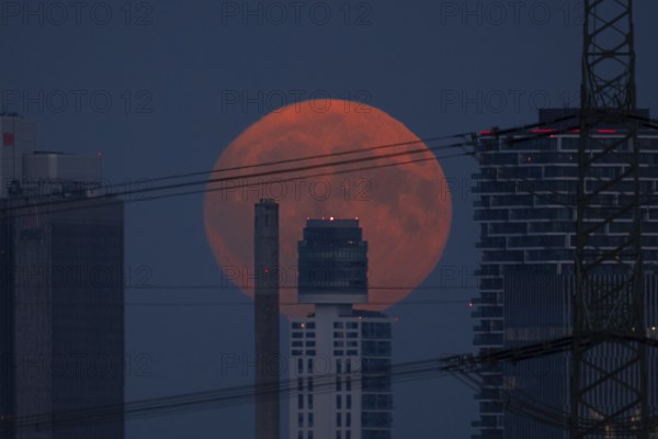 The full moon rises behind the Henniger Tower in Frankfurt am Main, Frankfurt am Main, Hesse, Germany