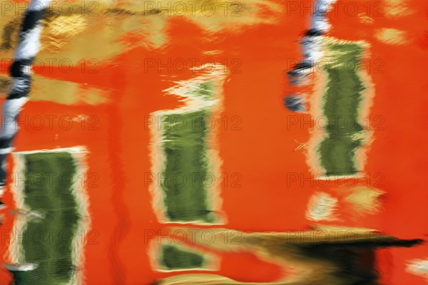 Colourful façade detail reflected in the water of a canal, Burano, Venice, Veneto, Italy