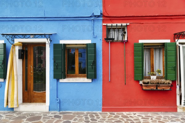 Colourful facade detail, broom hanging on the wall, Burano, island in the lagoon of Venice, Italy