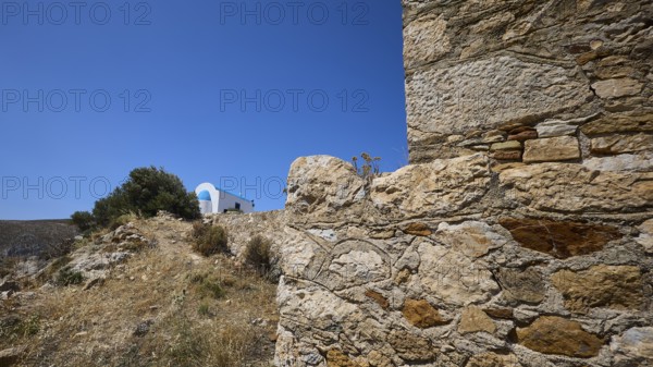 Stone wall in the foreground with blue roof in the background under a clear sky, Panagia tou Paleokastro, Church of the Old Fortress, Chapel, Panagia Kasteli, Lepides, Leros, Dodecanese, Greek Islands, Greece