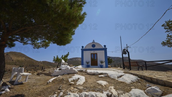 Small white-blue chapel under a tree with a bench in a rural setting, Panagia tou Paleokastro, Church of the Old Fortress, Chapel, Panagia Kasteli, Lepides, Leros, Dodecanese, Greek Islands, Greece