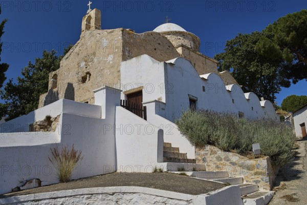Side view of a whitewashed stone church with surrounding trees, Basilica, Church, Agios Theologos, Leros, Dodecanese, Greek Islands, Greece