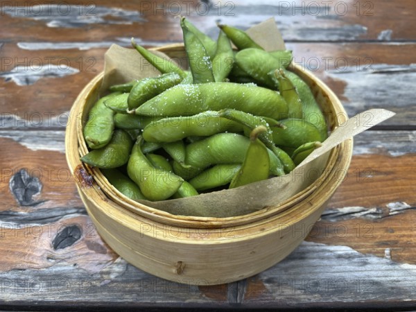 Portion of edamame, soya beans with salt, bowl, wooden table, Stuttgart, Baden-Württemberg, Germany