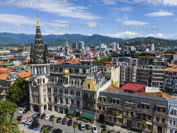 Charming city with historic architecture against a backdrop of mountains and blue sky, aerial view, astronomical clock, Black Gold Roof, Europe Square, Batumi, Black Sea, Adjara region, Adjara, autonomous republic, Georgia