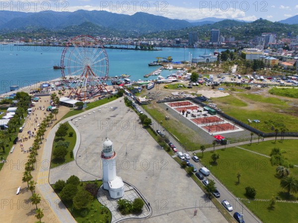 Aerial view of a harbour area with Ferris wheel, lighthouse and town by the sea, surrounded by mountains, aerial view, Pitsunda lighthouse, Miracle Park, Batumi, Black Sea, Adjara region, Adjara, autonomous republic, Georgia