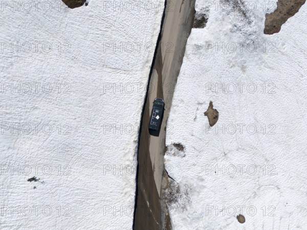 Aerial view of a car driving on a narrow snowy road between high snow walls, aerial view, camper, motorhome, on the way to Goderdzi Pass, Adjara region, Adjara, Autonomous Republic, Georgia