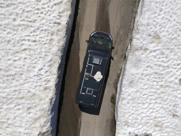Car driving between high snow walls on a narrow road, seen from above, aerial view, camper, motorhome, on the way to Goderdzi Pass, Adjara region, Adjara, autonomous republic, Georgia