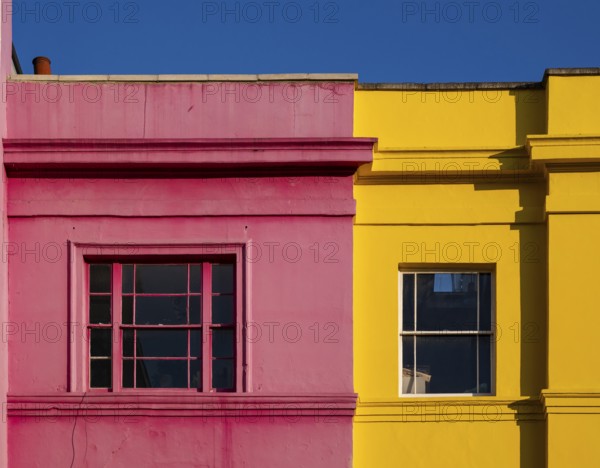 Colourful building facades in pink and yellow, blue sky, Portobello Road, Notting Hill, London, England, Great Britain