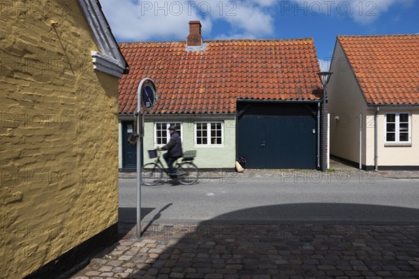 Cyclist on sunny street with colourful brick houses, Old Town, Ringkøbing, Ringkøbing Fjord, Denmark