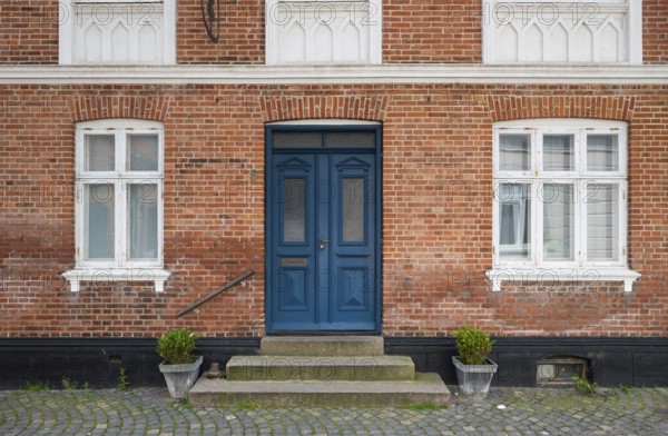 Brick façade with a striking blue door and potted plants, Old Town, Ringkøbing, Ringkøbing Fjord, Denmark