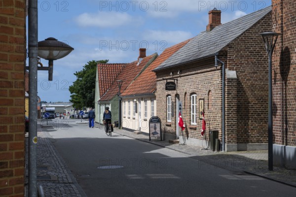 Street with historic brick houses and cyclists, Old Town, Ringkøbing, Ringkøbing Fjord, Denmark