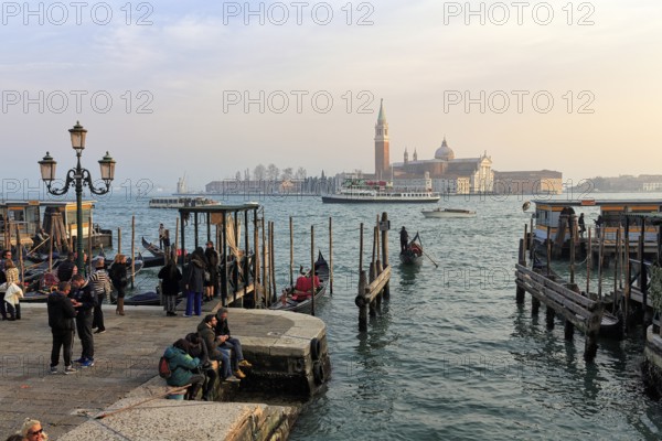 Boat dock at St Mark's Square, San Giorgio Maggiore church in the background, evening sky, Venice, Italy