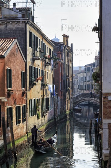 Gondola in winter, gondoliers on a canal, typical street scene in Venice, Italy