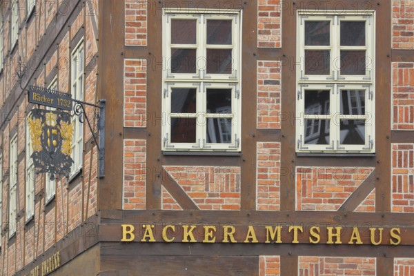 Nose plate with golden year on a brick house, half-timbered house, house facade, window, wrought iron work, handicraft, golden, inscription, bakery, bakery office building, market square, Hildesheim, Lower Saxony, Germany