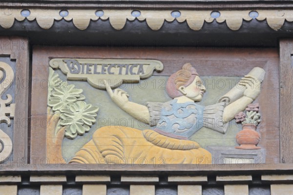 Allegorical woodcarving with figure on dialectics, philosophy, rhetoric talk, conversation, scroll, Renaissance, allegory, symbol, handicraft, art, painting, Latin inscription, detail, decoration, Wedekindhaus, Sparkasse, market square, Hildesheim, Lower Saxony, Germany
