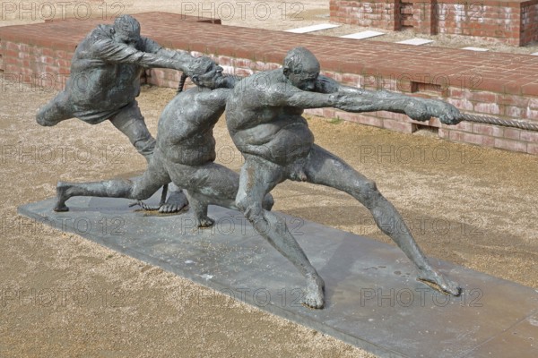 Tug-of-war by Karl-Henning Seemann 1987, bronze sculpture, modern art, tug-of-war, rope, sport, fighting, pulling, strength, St Mary's Church Tower, Wismar, Mecklenburg-Western Pomerania, Germany