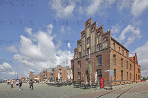 Brick building with stepped gable at the harbour and pedestrians, tourists, houses, stepped gable, Wismar, Mecklenburg-Western Pomerania, Germany