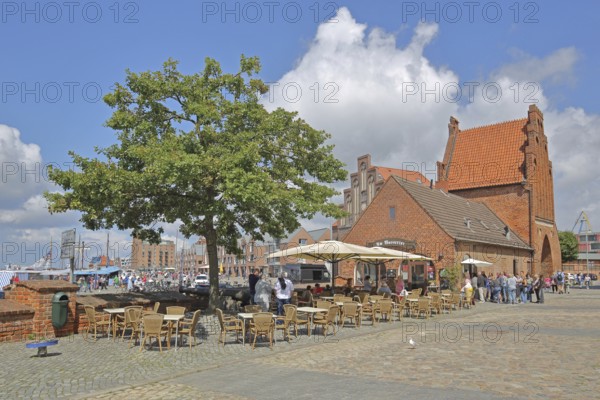 Historic water gate as part of the former town fortifications, street pub, restaurant, pedestrian, brick gothic, brick building, town gate, stepped gable, stepped gable, stepped gable, Old Harbour, Wismar, Mecklenburg-Western Pomerania, Germany