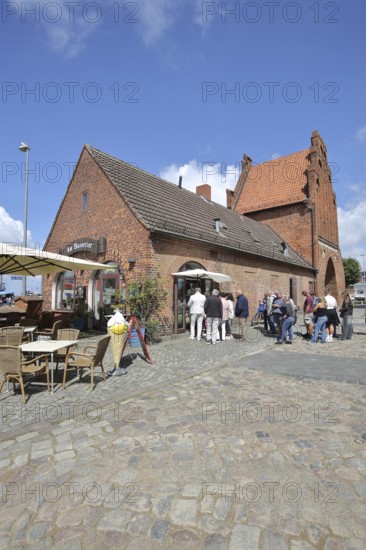 Historic water gate as part of the former town fortifications, street pub, restaurant, pedestrian, brick gothic, brick building, town gate, stepped gable, stepped gable, stepped gable, Wismar, Mecklenburg-Vorpommern, Germany